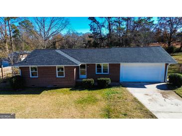 Charming brick home featuring an attached garage and well-maintained front yard at 6268 Mount Zion Blvd, Morrow, GA 30260