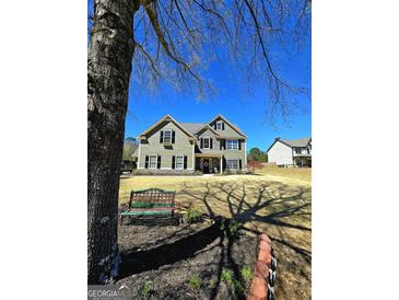 Charming two-story home with stone accents, manicured lawn and inviting front porch at 1441 Henderson Ridge Ln, Loganville, GA 30052