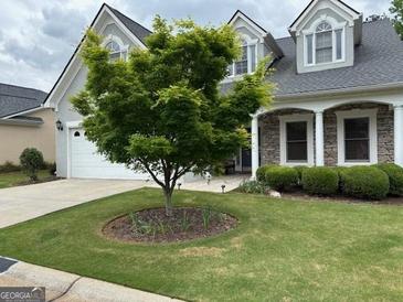 Charming home features a manicured lawn, stone accents, and a welcoming front entrance at 211 Collierstown Way, Peachtree City, GA 30269