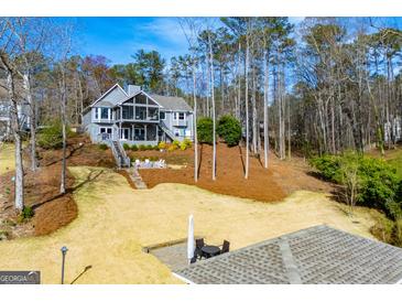 Charming gray home with a screened-in porch and outdoor seating on a sunny, landscaped lot at 2304 Larchmont Ct, Villa Rica, GA 30180
