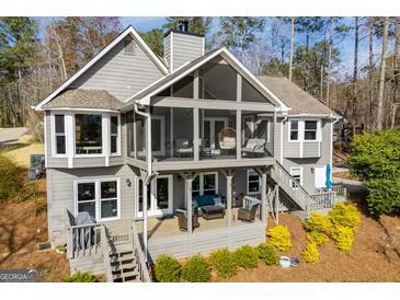 Beautiful gray home featuring a screened-in porch with modern outdoor furniture, and a tiered deck for entertaining at 2304 Larchmont Ct, Villa Rica, GA 30180
