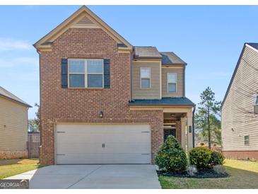 Charming two-story brick home with attached garage, landscaped front yard and inviting curb appeal at 1064 Lear Dr, Locust Grove, GA 30248
