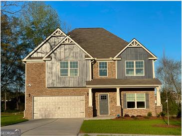 Charming two-story home features a brick and siding exterior, attached garage, and well-maintained lawn at 101 Elkins Blvd # 53, Locust Grove, GA 30248