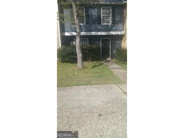 Two-story townhome featuring a gray exterior, black shutters, and a well-maintained front yard at 8547 Jamestown Way, Jonesboro, GA 30238