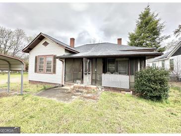 Charming home featuring a cozy screened porch and traditional architectural details at 45 Poplar St, Porterdale, GA 30014