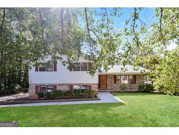 Charming split-level home featuring a well-maintained lawn, brick accents and fresh landscaping at 1343 Burbank Trl, Morrow, GA 30260