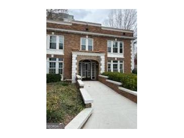 Charming red brick apartment building with white trim, a walkway, and well-maintained landscaping at 242 12Th St Ne 1 1A, Atlanta, GA 30309