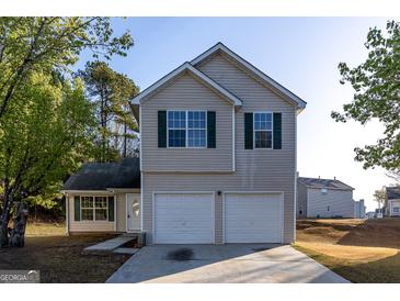 Charming two-story home with a two-car garage, green shutters, and a well-maintained front yard at 2536 Lancewood Ln, Lithonia, GA 30058