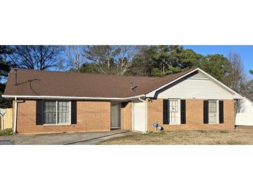 Charming one story brick home featuring black shutters, a well-maintained roof, and an inviting entrance at 634 S Jeff Davis Dr, Fayetteville, GA 30215