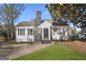 Charming home featuring a stone chimney, black shutters, and a well-manicured lawn at 2377 Beecher Sw Rd, Atlanta, GA 30311