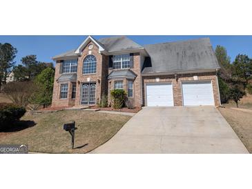 Charming brick home featuring a two-car garage and a well-maintained front yard at 159 Courtneys Ln, Fayetteville, GA 30215