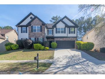 Charming two-story home featuring a stone facade, dark shutters, and a well-manicured front lawn at 8030 Snapwell Dr, Fairburn, GA 30213