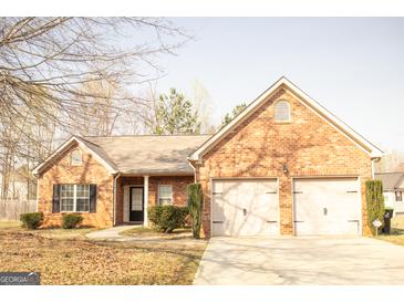 Charming single-story brick home featuring an attached two-car garage at 1109 Norsworthy Ml, Hampton, GA 30228