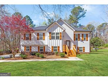Charming two-story home with white siding, wood shutters, stone accents, and a well-manicured lawn at 275 Cedars Glen Cir, Villa Rica, GA 30180