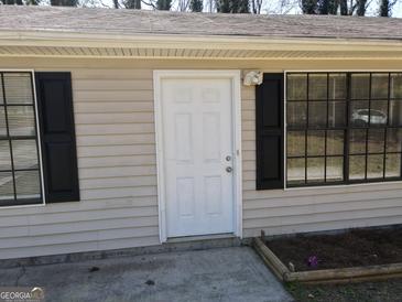 The exterior front door of this home features dual windows and a light fixture at 61 Scoby Ct, Jonesboro, GA 30238