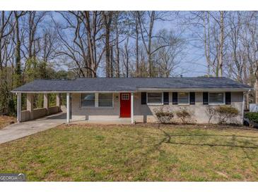 Charming single-story home with a brick facade, red door and a convenient carport at 3465 Tulip Dr, Decatur, GA 30032