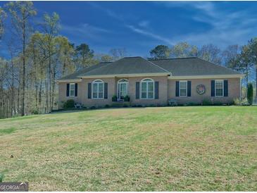 Charming brick home featuring a well-maintained lawn, arched windows and classic black shutters at 809 Mcbean Ct, Mcdonough, GA 30252