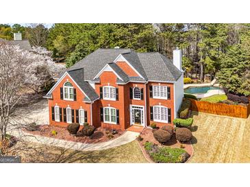 Stunning two-story red brick home with a well-manicured lawn and inviting swimming pool at 265 Ridgewood Dr, Fayetteville, GA 30215