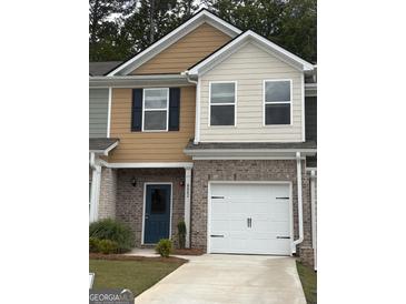 Charming two-story townhome featuring a brick facade, blue door, and attached one-car garage at 8642 Lakeview Commons # 36, Jonesboro, GA 30238