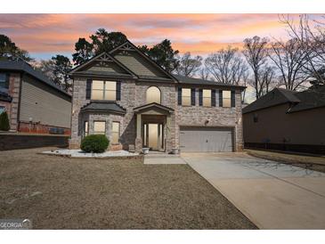 Charming two-story brick home with a manicured lawn and two car garage at 605 Camano Way, Mcdonough, GA 30253