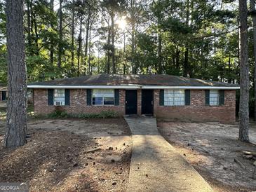 Charming brick multifamily home featuring a sidewalk leading to the front doors and green shutters, surrounded by trees at 6540 Lower Dixie Lake Rd, Union City, GA 30291