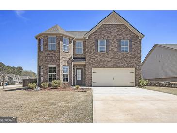 Two story brick home with attached two car garage and well manicured landscaping in a suburban neighborhood at 1734 Tricklin Spgs, Mcdonough, GA 30252