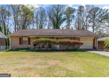 Charming brick ranch home with a manicured lawn, blossoming azaleas, and an attached garage at 447 Wavelyn Way, Riverdale, GA 30274