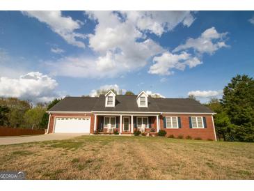 Charming, single-story brick home featuring a two-car garage and dormer windows at 237 Summerford Pl, Stockbridge, GA 30281