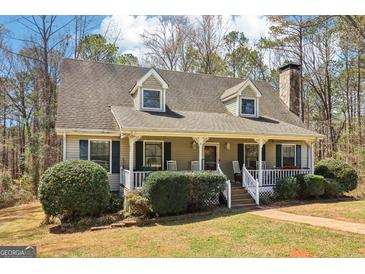 Charming home featuring a cozy front porch, dormer windows, and landscaped yard, creating a welcoming curb appeal at 375 Wellington Mill Rd, Whitesburg, GA 30185