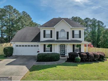 Charming two-story traditional home featuring a well-manicured lawn and a welcoming front porch at 720 Strawflower Ln, Locust Grove, GA 30248
