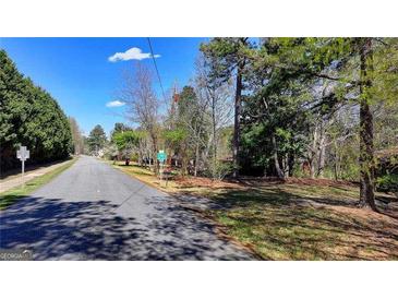 Neighborhood street view lined with mature trees and single-Gathering homes on a sunny day at 768 Scales Rd, Suwanee, GA 30024
