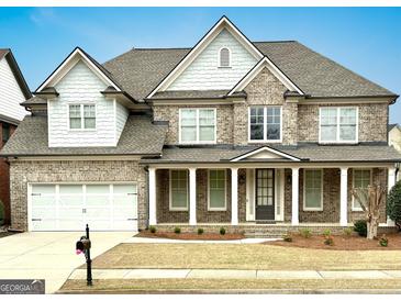 Beautiful two-story brick home with a well-manicured front yard and a charming covered porch at 3393 Willow Glen Trl, Suwanee, GA 30024