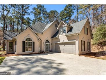Charming two-story home with a neutral exterior, well-manicured lawn, and mature trees at 5163 Holly Springs Dr, Douglasville, GA 30135