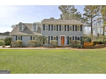 Traditional two-story home featuring a well-manicured lawn and mature landscaping around the facade at 233 Creekstone Bnd, Peachtree City, GA 30269