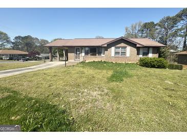 Charming single story brick home with carport and front yard featuring an easy to maintain lawn at 2574 Rosedale Dr, Morrow, GA 30260
