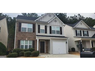 Charming two-story home featuring a combination of brick and siding exterior, a well-maintained lawn, and a one car garage at 9487 Lakeview Rd, Union City, GA 30291