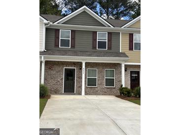 Charming townhome with brick facade, covered entryway, and well-maintained landscaping at 8654 Lakeview Commons # 38, Jonesboro, GA 30238
