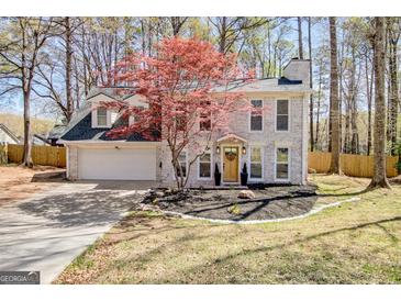 Charming two-story home featuring a brick facade, attached garage, and mature landscaping at 104 Pine Pt, Peachtree City, GA 30269