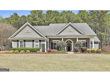 Charming single-story home features manicured landscaping, traditional design, and a welcoming front porch at 410 Denton Cir, Fayetteville, GA 30215