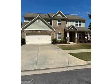 Two-story home featuring a brick and siding exterior, a two-car garage, and a well-maintained lawn at 2470 Wevok Way, Grayson, GA 30017