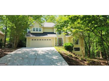 Charming two-story home with a well-manicured lawn and attached two car garage, surrounded by lush trees at 3626 Lone Indian Trl, Marietta, GA 30066