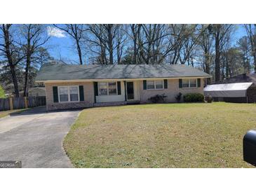 Charming brick ranch home with a well-maintained front yard and a long concrete driveway at 617 Virginia Cir, Forest Park, GA 30297