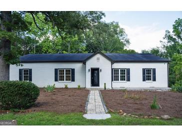 Charming white brick home featuring black shutters and a welcoming walkway to the front door at 281 New Hope Dr, Mcdonough, GA 30252