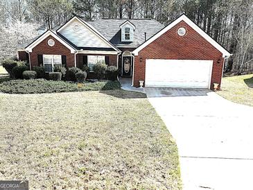 Charming brick home featuring a well-manicured front yard and attached two-car garage at 40 Pebble Brooke Ct, Covington, GA 30016