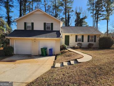 Charming two-story home with attached two-car garage and well-maintained lawn at 6733 Jojanne Ln, Lithonia, GA 30038