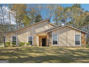Charming single-story home featuring stone accents, neutral siding and lush landscaping at 3396 Framingham Dr, Lithonia, GA 30038