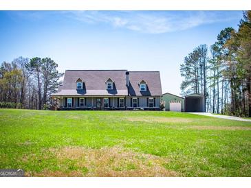Charming home featuring a large front yard, covered porch, and a detached garage at 640 Lovell Rd, Temple, GA 30179