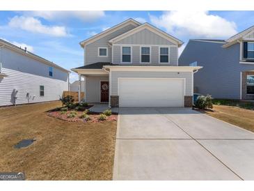 Charming two-story home features a two-car garage and a well-maintained front yard with fresh landscaping at 813 Royal Red Ct, Mcdonough, GA 30253