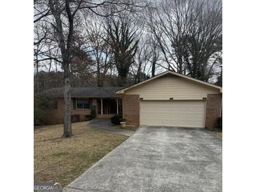 Traditional brick home featuring an attached two-car garage and a well-maintained front lawn at 2791 Biscayne Dr, Conyers, GA 30012