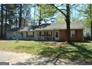Charming one-story home with light blue siding, brick accents, red shutters, and a welcoming front porch at 121 Juniper Dr, Mcdonough, GA 30253